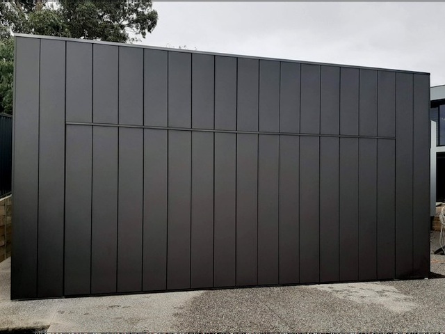 Charcoal vertical batten flush finish tilt garage door.